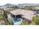 A house with a stunning backyard featuring a pool, jacuzzi, outdoor cooking space, manicured greenery and mountain view at 5410 Serenity Brook Dr, Las Vegas, NV 89149