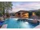 Stunning backyard with pool, spa, cascading water features, and outdoor bar area at dusk at 5410 Serenity Brook Dr, Las Vegas, NV 89149