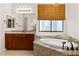 Lavish bathroom featuring granite-surround soaking tub and matching cabinets at 5410 Serenity Brook Dr, Las Vegas, NV 89149
