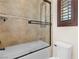 Bathroom with a shower-over-tub, decorative tile, and a frosted glass shower door at 5410 Serenity Brook Dr, Las Vegas, NV 89149