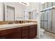 Bathroom featuring double sinks, tile countertops, and a walk-in shower with glass enclosure and tile walls at 5410 Serenity Brook Dr, Las Vegas, NV 89149