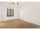 Bright, empty bedroom featuring neutral walls, carpet flooring, a ceiling fan, and a window with wooden shutters at 5410 Serenity Brook Dr, Las Vegas, NV 89149
