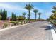 Gated community entrance with lush landscaping, palm trees, and stone-paved roads offering privacy at 5410 Serenity Brook Dr, Las Vegas, NV 89149
