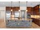 Gourmet kitchen featuring stone island with granite countertop, stainless appliances, and custom wood cabinetry at 5410 Serenity Brook Dr, Las Vegas, NV 89149