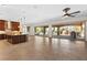 Open-concept living room with gourmet kitchen, tile flooring, and seamless access to an outdoor pool and patio at 5410 Serenity Brook Dr, Las Vegas, NV 89149