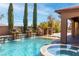 Relaxing pool area with a spa and decorative water features, surrounded by lush greenery at 5410 Serenity Brook Dr, Las Vegas, NV 89149