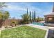 A backyard featuring a large pool, raised spa, weeping wall, and artificial grass at 5410 Serenity Brook Dr, Las Vegas, NV 89149
