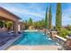 Sparkling backyard pool with water features, lush landscaping, and a serene outdoor setting at 5410 Serenity Brook Dr, Las Vegas, NV 89149