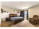 Spacious bedroom featuring a large bed, recliner, and balcony access at 555 Rene Ln, Henderson, NV 89015