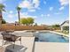 Beautiful backyard with pool, outdoor seating area, fire pit, and tropical plants at 5865 Egan Crest Dr, Las Vegas, NV 89149