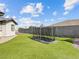 Spacious backyard area showing lush green lawn with an in-ground trampoline for recreational activities at 5865 Egan Crest Dr, Las Vegas, NV 89149
