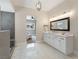 Bright bathroom with marble floors, a walk-in shower with bench, and a double vanity with modern fixtures at 5865 Egan Crest Dr, Las Vegas, NV 89149