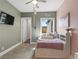 Cozy bedroom painted in green and pink with carpet floors and an exterior view at 5865 Egan Crest Dr, Las Vegas, NV 89149