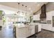 Bright kitchen with a large island, farmhouse sink, stainless steel appliances, and open layout to the living area at 5865 Egan Crest Dr, Las Vegas, NV 89149