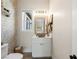 Charming powder room with decorative wallpaper, farmhouse-style mirror, and rustic vanity at 5865 Egan Crest Dr, Las Vegas, NV 89149