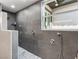 A luxurious shower featuring grey stone tiles, pebble floor, and multiple shower heads for a spa-like experience at 5865 Egan Crest Dr, Las Vegas, NV 89149