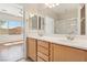 The bathroom features a double sink vanity, a large mirror, and a shower and tub at 6059 Wheat Penny Ave, Las Vegas, NV 89122