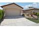 Charming home exterior with a two-car garage, landscaped yard, and inviting curb appeal at 6059 Wheat Penny Ave, Las Vegas, NV 89122