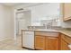 Open concept kitchen with tile floors, light wood cabinets, white appliances, and a functional breakfast bar at 6059 Wheat Penny Ave, Las Vegas, NV 89122