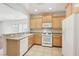 Charming kitchen with tile floors, light wood cabinets, white appliances, and a breakfast bar, for efficient functionality at 6059 Wheat Penny Ave, Las Vegas, NV 89122