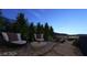 Serene outdoor seating area with comfortable chairs and a small table, surrounded by lush greenery and city view at 611 Grand Rim Dr, Henderson, NV 89012