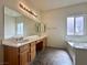 Bathroom featuring a double sink vanity, a garden tub, and neutral color palette at 632 Hitchen Post Dr, Henderson, NV 89011