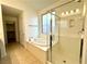 Luxurious bathroom with a soaking tub, glass-enclosed shower, and tile flooring at 7253 Blooming Jasmine Ave, Las Vegas, NV 89117