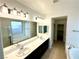 Bright bathroom featuring dual sinks, separate tub, and a large mirror with vanity lights at 7253 Blooming Jasmine Ave, Las Vegas, NV 89117