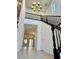 Inviting entryway with high ceilings, chandelier and views of the living area, and black staircase at 7253 Blooming Jasmine Ave, Las Vegas, NV 89117