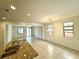Open-concept living space with tile flooring, natural light, and view of kitchen at 7253 Blooming Jasmine Ave, Las Vegas, NV 89117