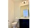 Neat powder room featuring a toilet, vanity with dark wood cabinets and a mirror with modern lighting at 7253 Blooming Jasmine Ave, Las Vegas, NV 89117