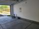 Spacious garage with concrete flooring, paint buckets and an outside view of landscaped yard at 7334 N Decatur Blvd # 6, Las Vegas, NV 89131