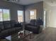 Bright living room featuring a comfortable leather sofa, glass coffee table, and large windows at 7334 N Decatur Blvd # 6, Las Vegas, NV 89131