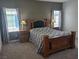 Cozy main bedroom with a wooden bed frame, carpet, and natural light from the windows at 7334 N Decatur Blvd # 6, Las Vegas, NV 89131