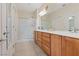 Bright bathroom with a double sink vanity, framed mirror, and glass-enclosed shower at 7452 Chaffinch St, North Las Vegas, NV 89084