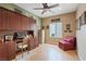 This home office boasts a built-in desk and shelving with natural light and a cozy chair at 7452 Chaffinch St, North Las Vegas, NV 89084