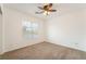 A carpeted bedroom with a ceiling fan and a large window with blinds at 810 Socorro Song Ln, Henderson, NV 89052