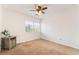A carpeted bedroom featuring a ceiling fan, a window, and a bedside table at 810 Socorro Song Ln, Henderson, NV 89052