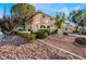 The exterior of the home features well-manicured landscaping and a rock garden at 810 Socorro Song Ln, Henderson, NV 89052
