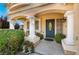Inviting front entrance with a blue door, classic columns, and well-maintained landscaping around the porch at 810 Socorro Song Ln, Henderson, NV 89052