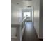 Bright hallway with hardwood floors, white walls and trim and a window at the end at 810 Socorro Song Ln, Henderson, NV 89052