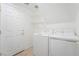 Clean laundry room featuring modern washer and dryer units, shelving, and neutral tile flooring at 810 Socorro Song Ln, Henderson, NV 89052