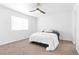This bright bedroom features neutral carpeting, a modern ceiling fan and a large window with blinds at 823 Crabapple Dr, Henderson, NV 89002