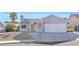 Charming single-story home features a two-car garage, manicured yard, and white rock landscaping at 823 Crabapple Dr, Henderson, NV 89002