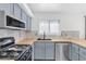Kitchen features stainless steel appliances, gray cabinets, modern hardware, wood counters and tiled backsplash at 823 Crabapple Dr, Henderson, NV 89002