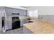 This kitchen features stainless steel appliances, gray cabinets, modern hardware and butcher block countertops at 823 Crabapple Dr, Henderson, NV 89002