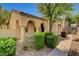 Charming home exterior with arched entry, landscaped garden, and well-maintained walkway at 8560 Alocasia Ct, Las Vegas, NV 89149