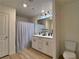 Well-lit bathroom featuring double vanity, modern fixtures, and wood-look tile flooring at 8710 Beverly Grove Ct, Las Vegas, NV 89113