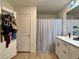 Clean bathroom with double sinks, white cabinetry, and a shower with a curtain at 8710 Beverly Grove Ct, Las Vegas, NV 89113