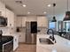 Bright, modern kitchen features white cabinets, stainless appliances, and a large island with seating at 8710 Beverly Grove Ct, Las Vegas, NV 89113